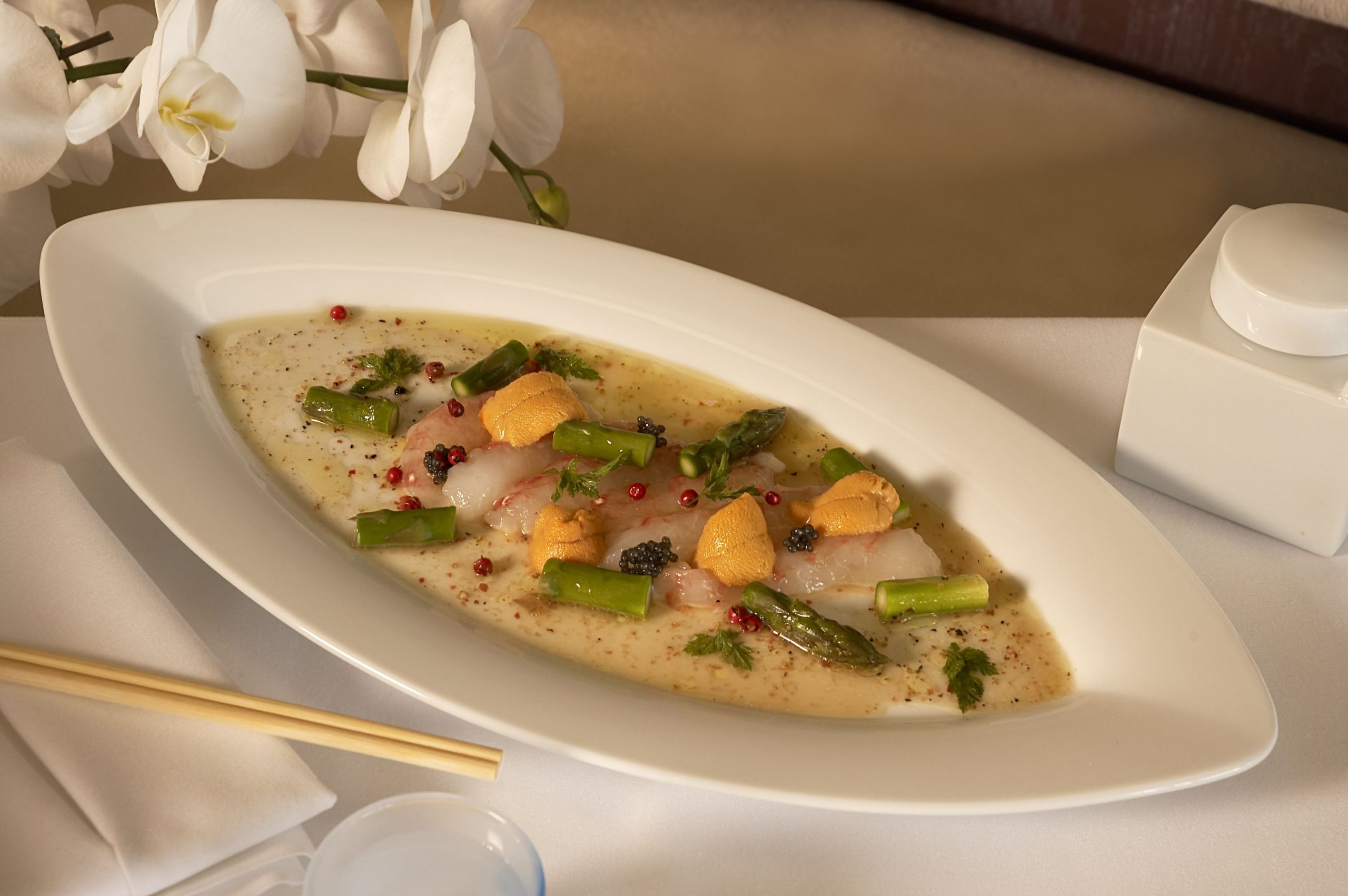 White fish carpaccio topped with sea urchin, asparagus, caviar and pink peppercorns