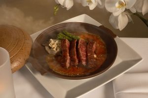 Seared wagyu beef with mushrooms and asparagus in a hot clay pot