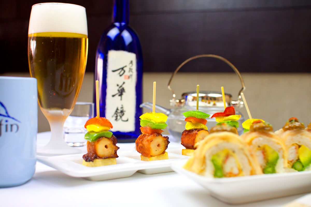 Skewers and sushi rolls served with a glass of beer