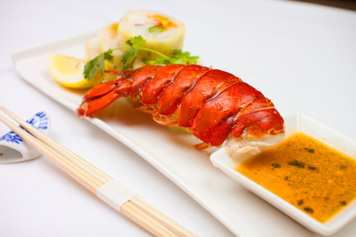 Grilled lobster tail with a bowl of dipping sauce